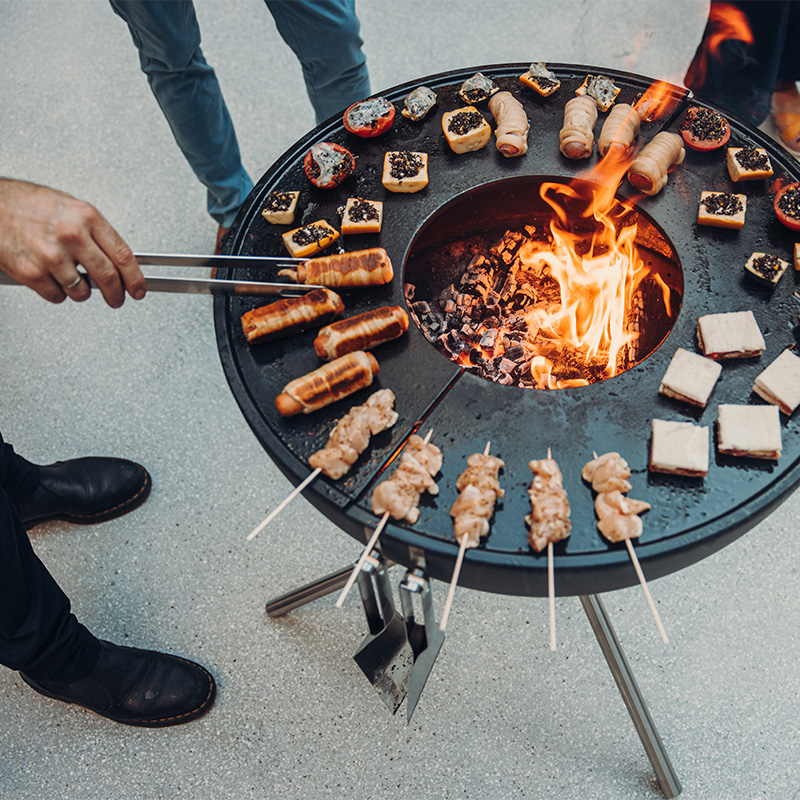 Hier is een man afgebeeld die eten aan het bereiden is op een grill.