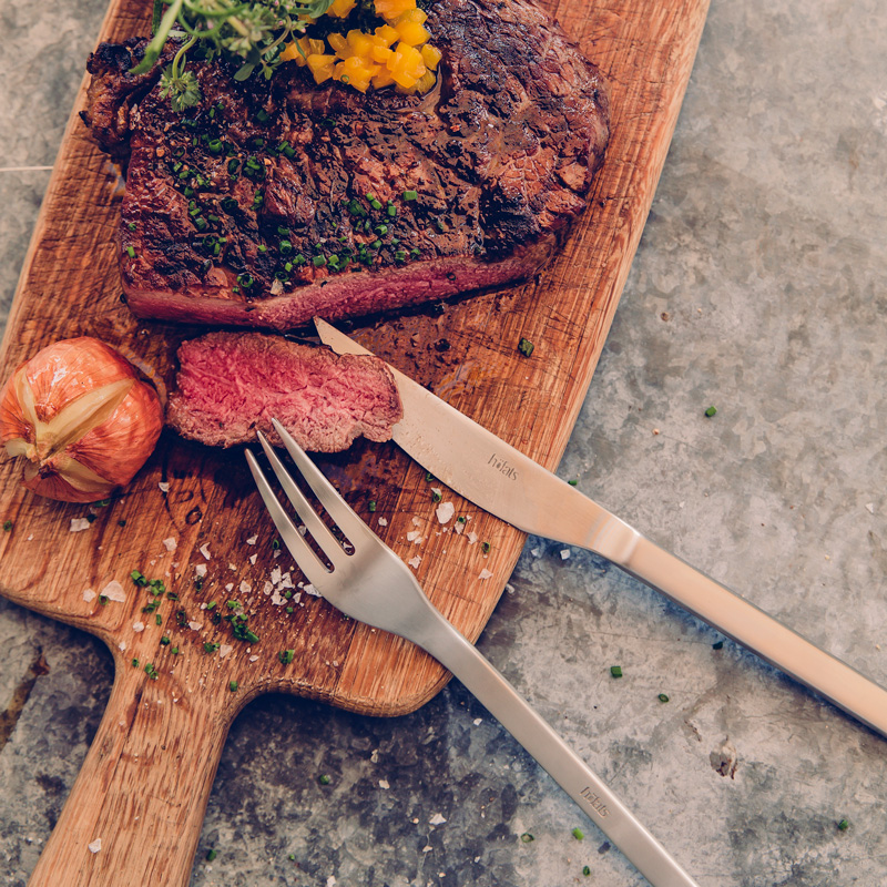 An image showing a steak and a knife on a cutting board