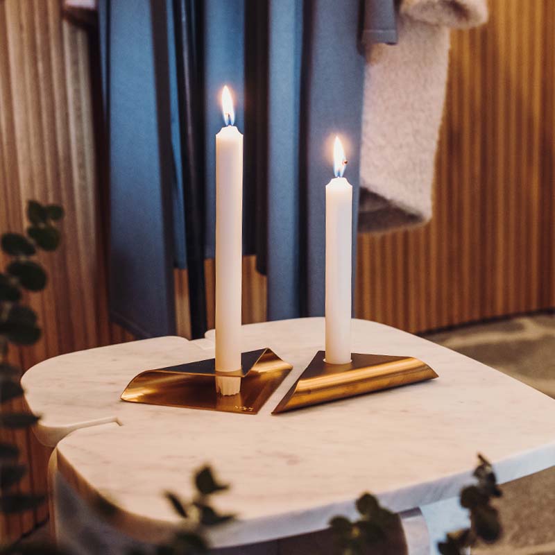 Een uitzicht op een kaars op een tafel met een handdoek en handdoek, met de SQUARE CANDLE Kaarsenhouder zwart.