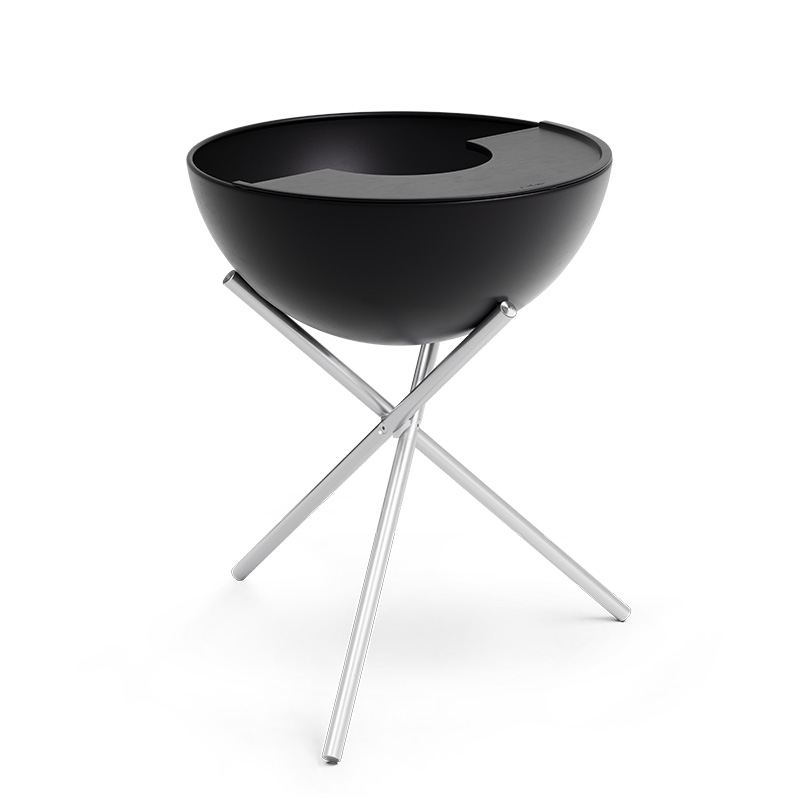 An inviting scene with a black bowl with a metal stand, highlighted by the presence of the 00263 Bowl 70 Plancha.