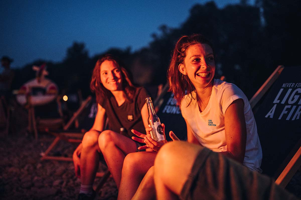 SHIRT Women grey L two women sitting on a beach chair at night.